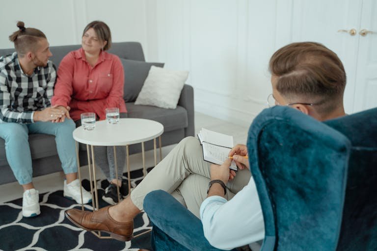 A couple engages in a counseling session with a therapist in an office setting, emphasizing communication.